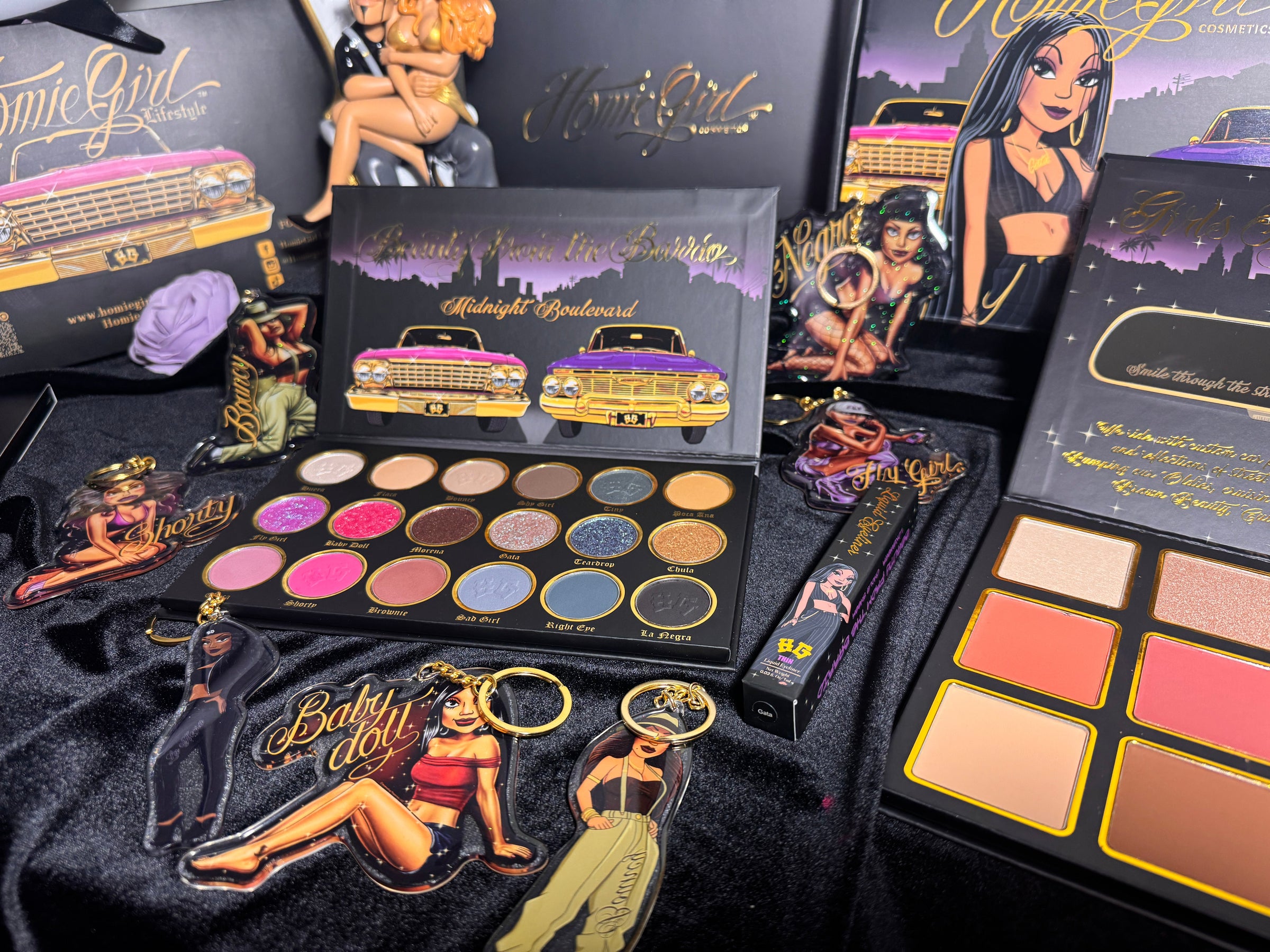 Photo of HomieGirl products including makeup palettes, underwear, stickers, and keychains styled together with Chicana street-style influence